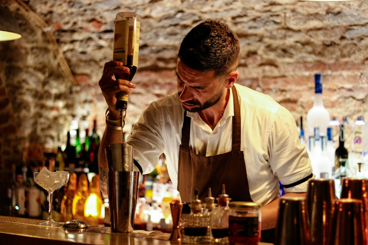 Bartender mixing a cocktail behind a bar counter
